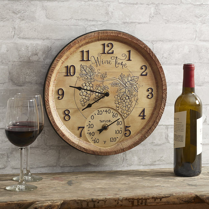 14 inch wine time wall clock with grape vine motif and thermometer, shown with a bottle of wine and two wine glasses