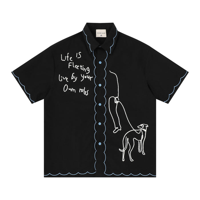Black oversized short sleeve shirt with blue scalloped trim, handwritten text, and abstract greyhound embroidery