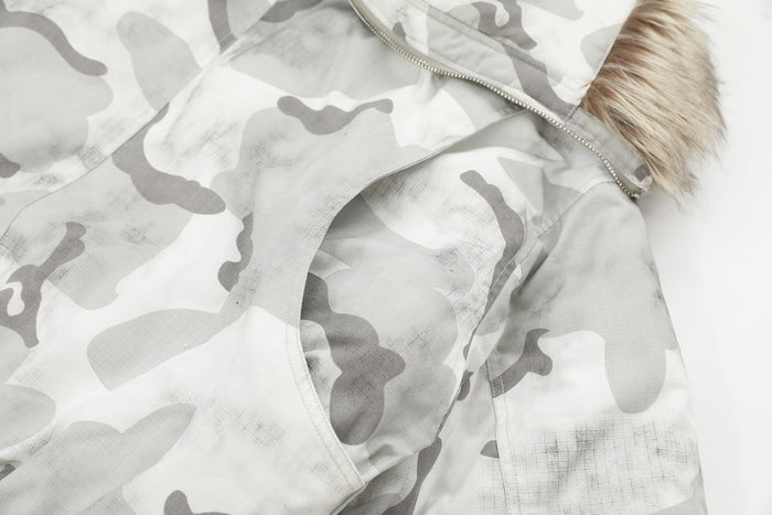 Close-up of snow camo jacket hood, zipper, and fur trim at the shoulder