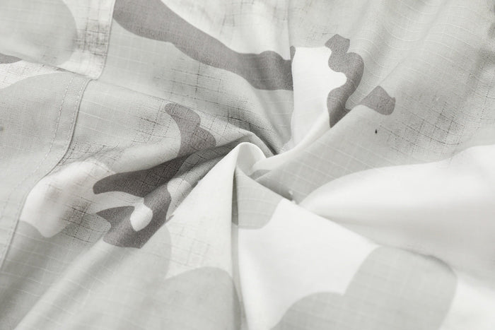 Close-up of snow camo fabric with white and gray pattern and textured weave