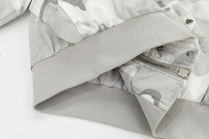 Close-up of jacket cuff, ribbed hem, and zipper detail in light gray