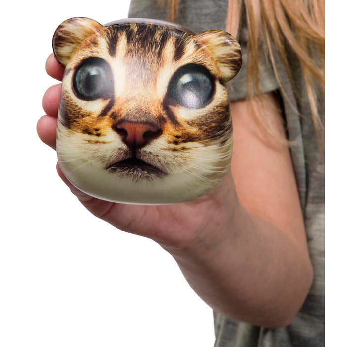 A person with long, light brown hair holds the Astroverse Catstronaut, a round squishy toy by Astroverse featuring a wide-eyed cat face and small ears, capturing an imaginative space explorer vibe.