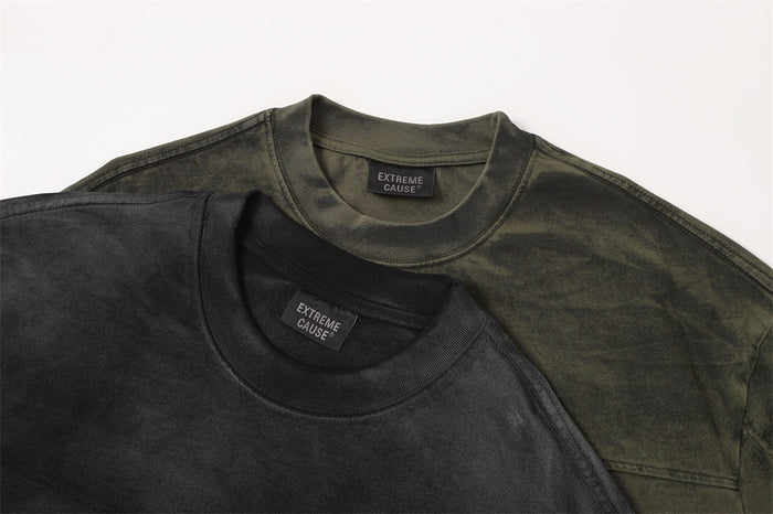 Two acid wash oversized distressed T-shirts in black and olive green with raw edge streetwear styling