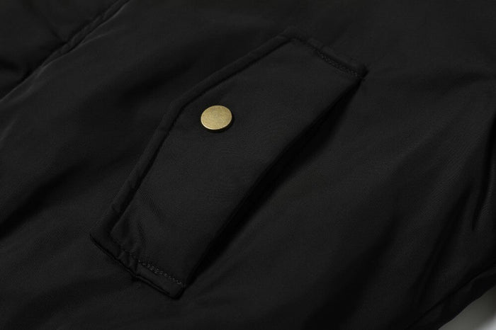 Close-up of black flap pocket with gold snap button