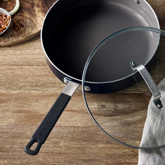 Black ceramic nonstick cookware set on a wooden surface.
