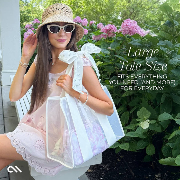 Woman holding ivory pearl bow jelly tote bag in garden with pink hydrangeas, wearing hat and sunglasses