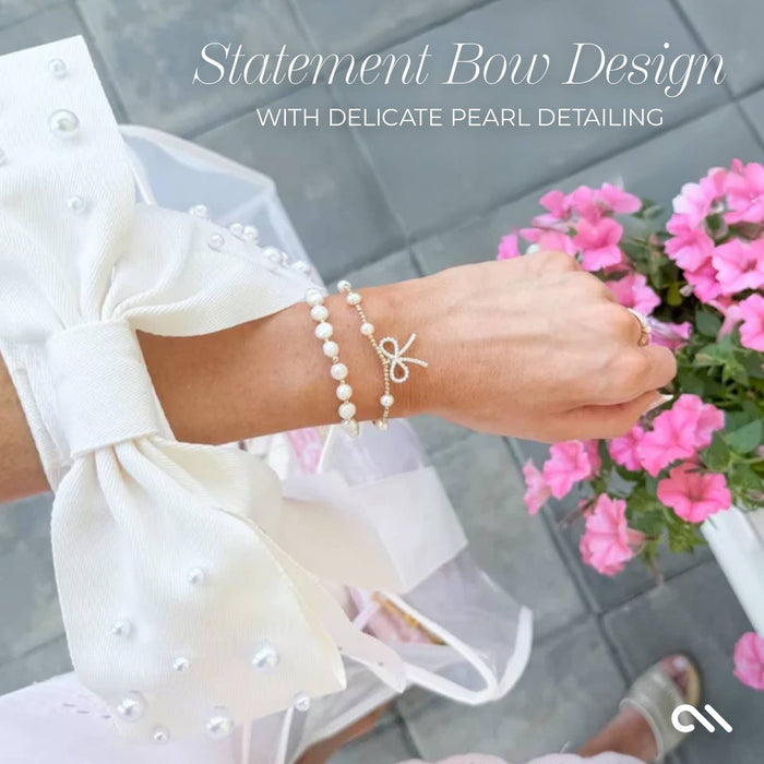 Ivory pearl bow jelly tote bag worn on wrist with pearl bracelets and white bow detail