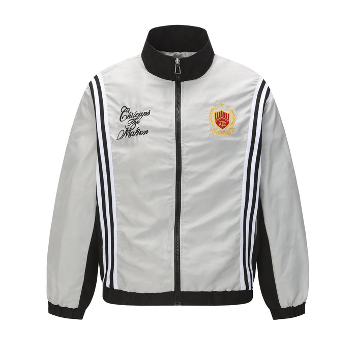 Light gray zip track jacket with black collar, side stripes, script chest text and crest patch