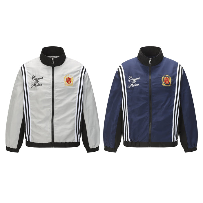 White and navy zip track jackets shown front view, each with black collar, stripes and chest graphics