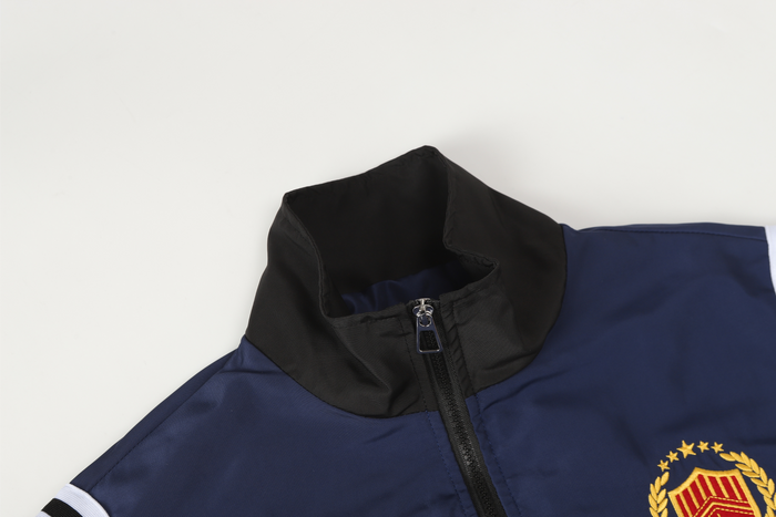 Close-up of navy track jacket collar and zipper with black stand collar and front seam