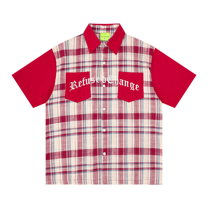 Front view of oversized plaid button-up shirt with red sleeves, navy collar, and graphic chest pockets