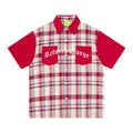 Front view of oversized plaid button-up shirt with red sleeves, navy collar, and graphic chest pockets