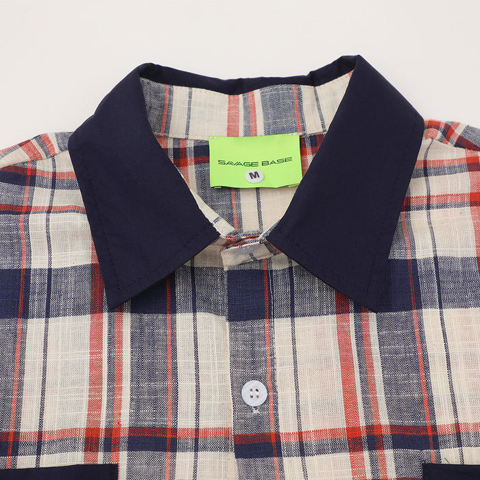 Close-up of navy collar and top button on plaid button-up shirt with green neck label