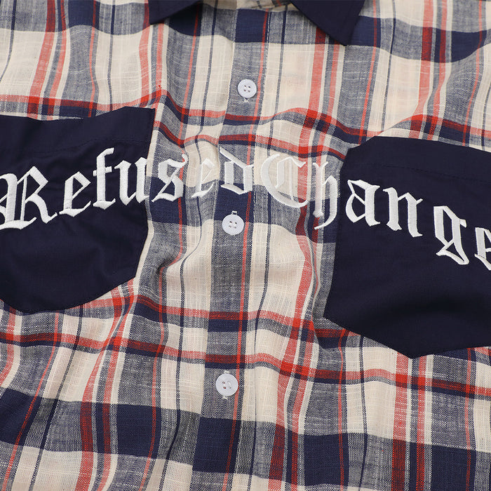 Close-up of graphic chest pockets on plaid shirt with navy panels and white lettering