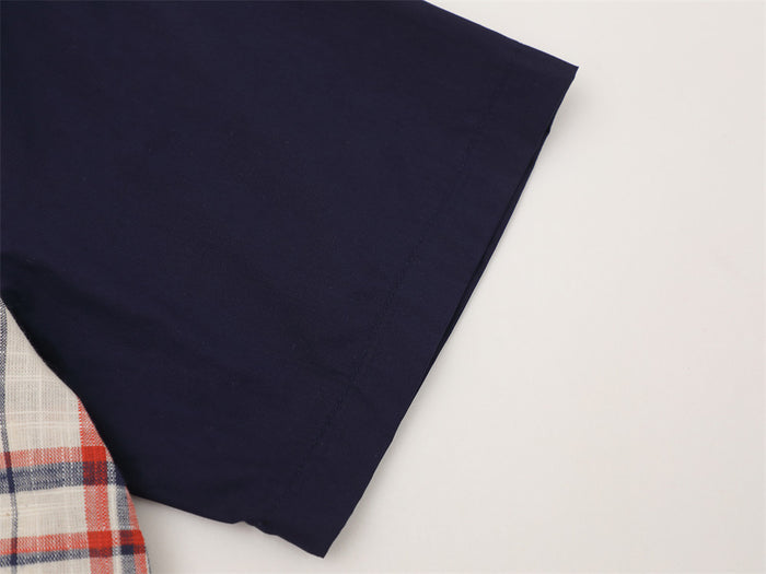 Close-up of solid navy short sleeve on plaid button-up shirt