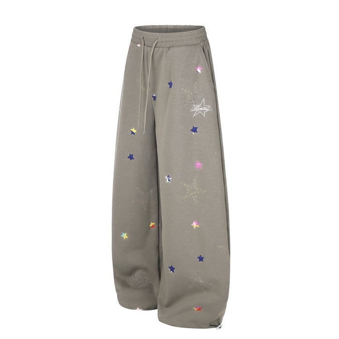 Taupe wide-leg sweatpants with multicolor star print, angled side view