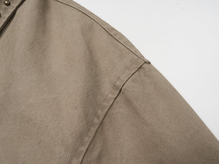 Close-up of shoulder seam on khaki washed cotton jacket