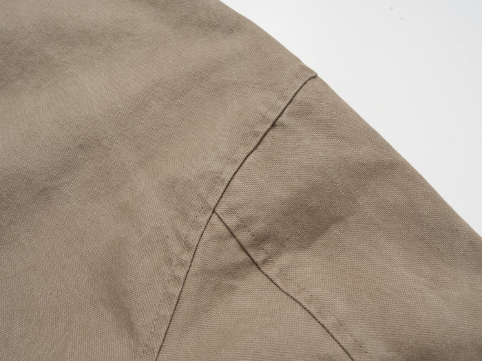 Close-up of shoulder and sleeve seam on khaki cotton work jacket