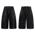 Crinkle-washed black wide-leg denim shorts with contrast white topstitching, front and back view