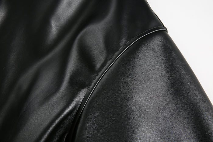 Close-up of black PU leather sleeve with stitched seam detail