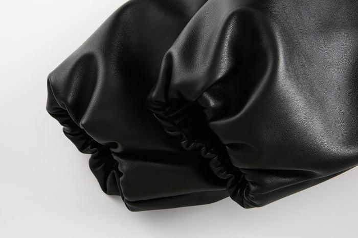 Close-up of black PU leather sleeve cuff with gathered elastic hem