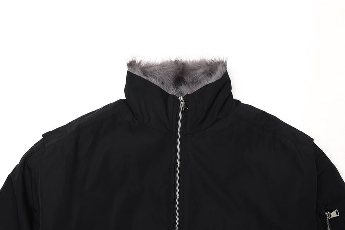 Close-up of black cropped bomber jacket collar with gray fur trim and zipper