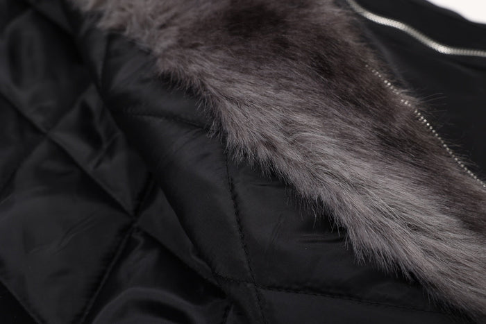 Close-up of black bomber jacket lining beside gray fur collar and zipper