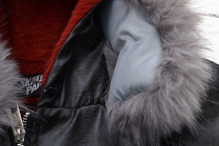 Close-up of hood lining and front collar area on black bomber jacket with gray faux fur