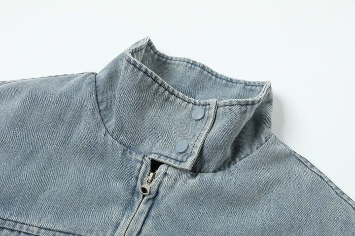 Close-up of light blue denim jacket collar with zipper and snap buttons