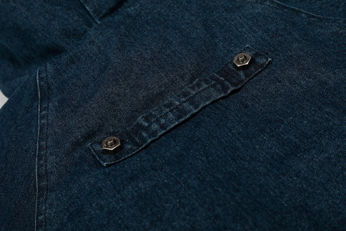 Close-up of deep indigo denim chest pocket flap with snap button