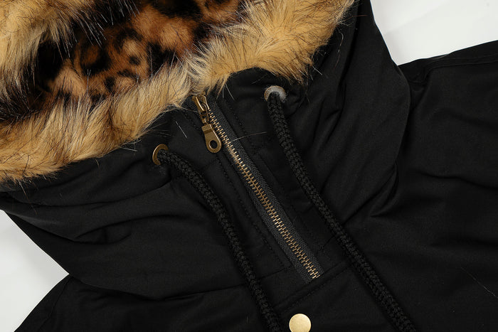 Close-up of black hooded jacket zipper, drawstrings, and faux-fur hood trim