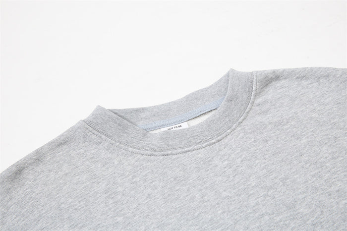 Close-up of light gray crewneck neckline and collar seam