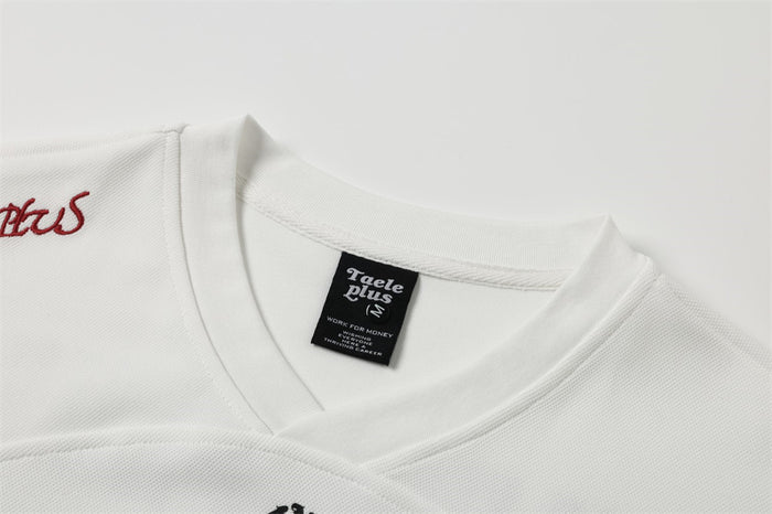 Close-up of white V-neck collar with Taele Plus neck label