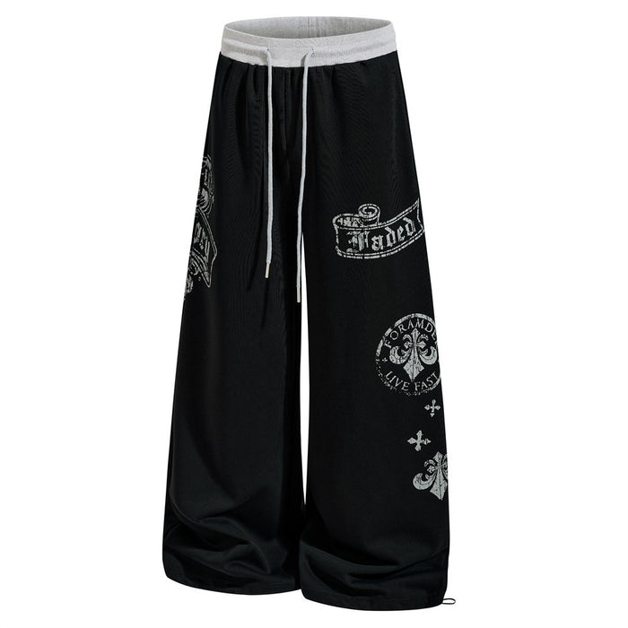 Black wide-leg sweatpants with gothic graphic prints, angled front view