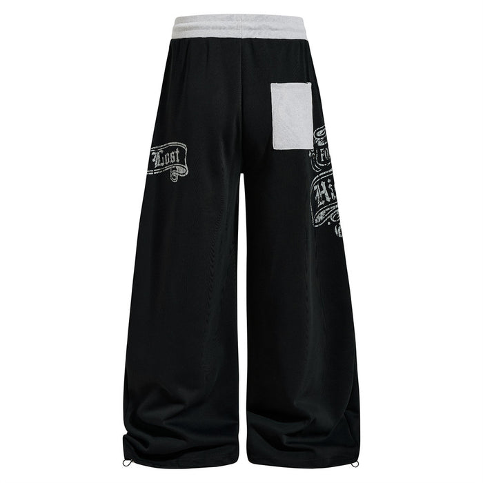 Black wide-leg sweatpants, back view with patch pocket and printed side graphic