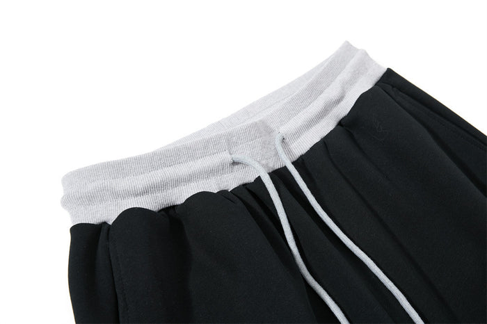 Close-up of black sweatpants waistband with light gray ribbed drawstring waist