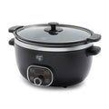 Black slow cooker with a glass lid on a white background