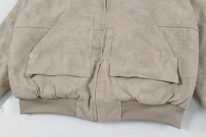 Close-up of front pockets and ribbed hem on beige hooded bomber jacket