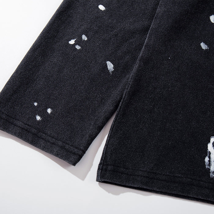 Close-up of black sleeve hem with distressed white paint splatter details