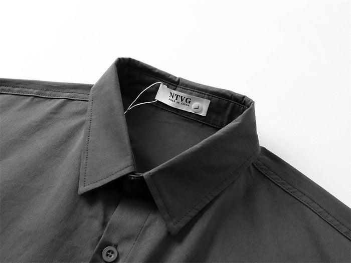 Close-up of dark gray shirt collar and top button with stitched seams