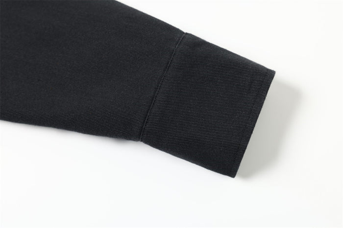 Black jacket sleeve cuff with plain hem and textured woven fabric