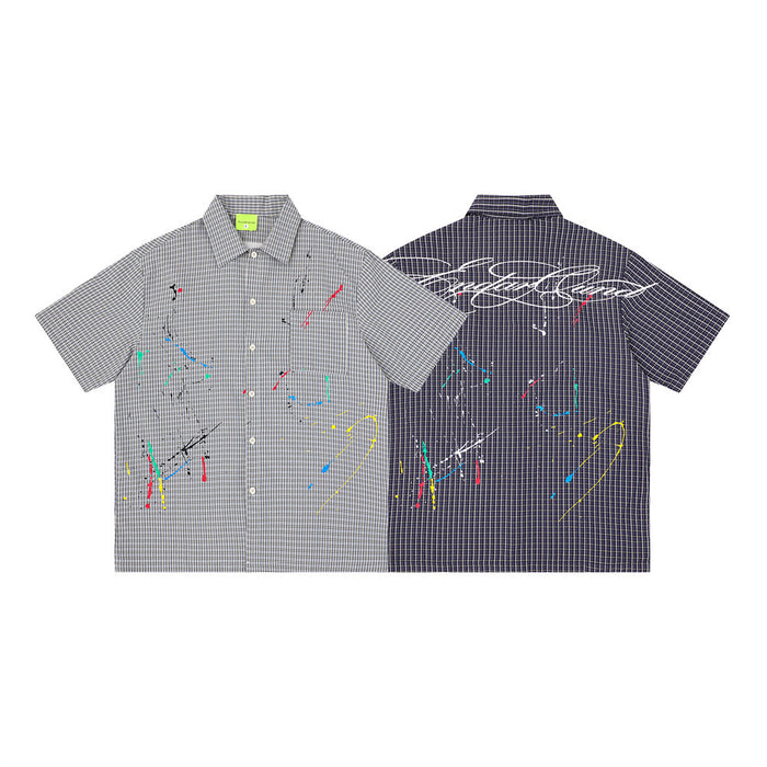 Short sleeve plaid button-up shirt in gray and navy with multicolor paint splatter and oversized back graphic