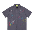 Men's oversized short sleeve plaid shirt with multicolor paint splatter embroidery on navy grid-check fabric, front and back