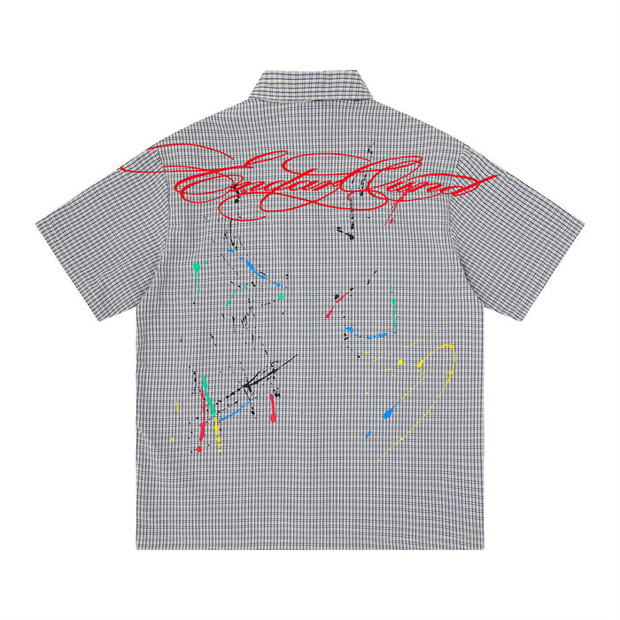Back view of gray plaid short sleeve shirt with red script graphic and multicolor paint splatter