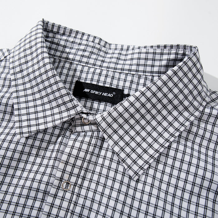 Close-up of plaid shirt collar and top button with brand label inside