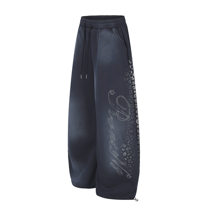 Side view of navy wide leg sweatpants with wide legs, tie-dye fade and script graphic