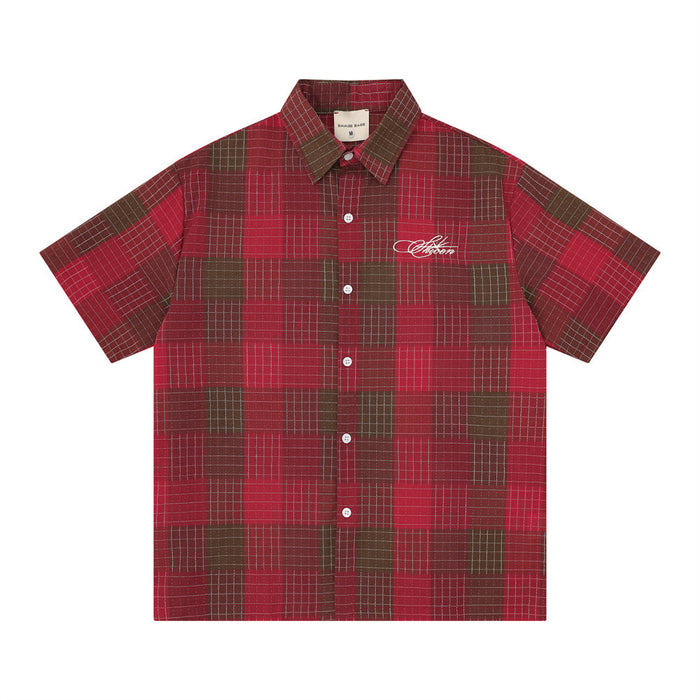 Red and brown plaid short sleeve button-up shirt with oversized fit and embroidered chest logo on white background