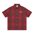 Red and brown plaid short sleeve button-up shirt with oversized fit and embroidered chest logo on white background