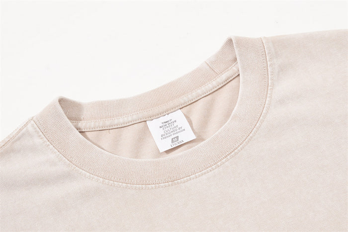 Close-up of beige crew neckline and label on oversized T-shirt