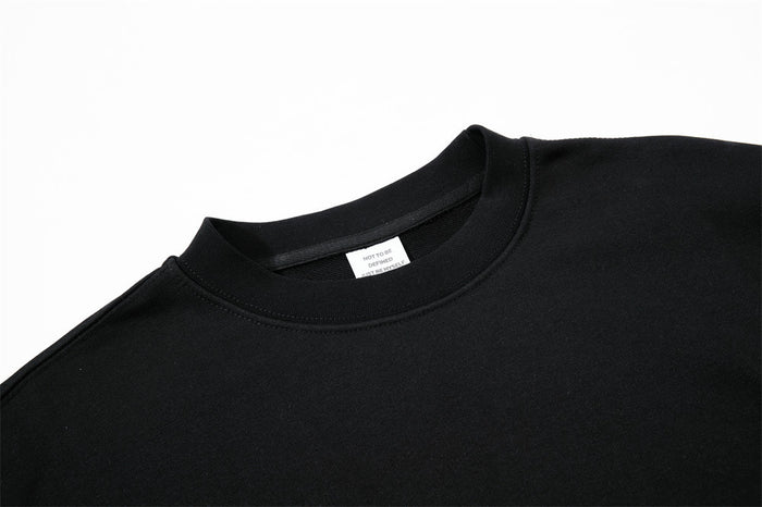 Close-up of black sweatshirt crew neck collar and inner label